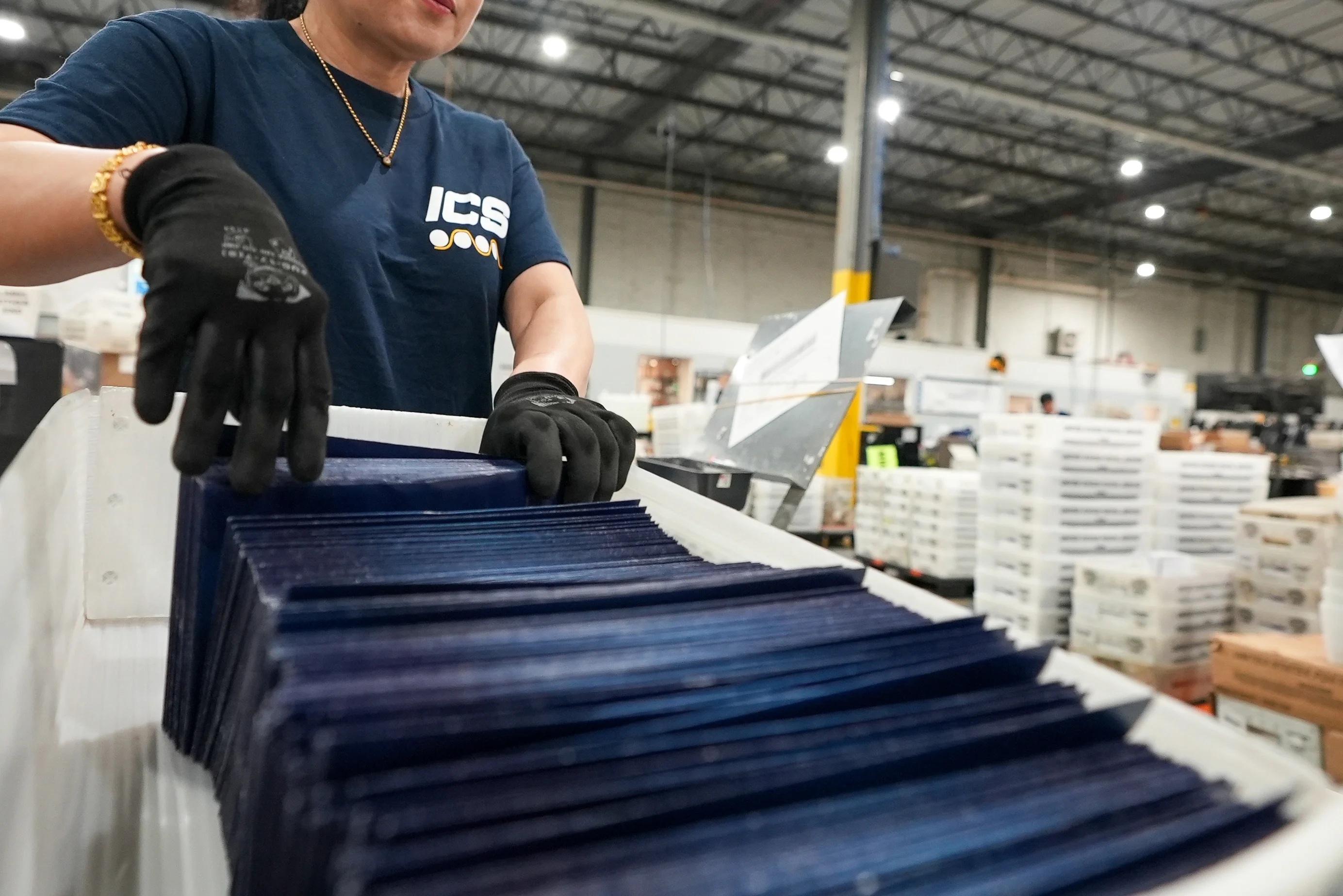 An ICS worker handles a tray of mail on the production floor