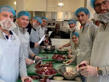 Trustifi team members preparing vegetables together in the Project Open Hand kitchen