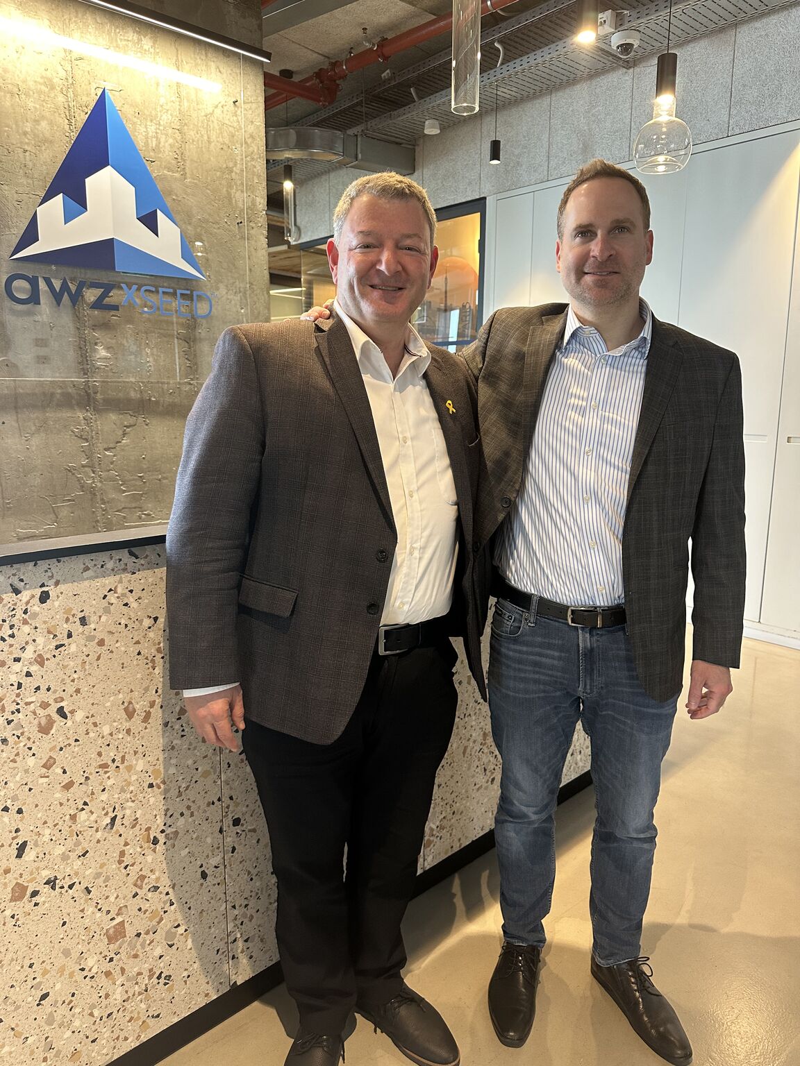 Ran Bar Or and Idan Zachar, right, standing beside the Awz X-Seed sign
