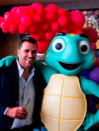 A guest with the Ime turtle mascot at the InsureMe launch celebration