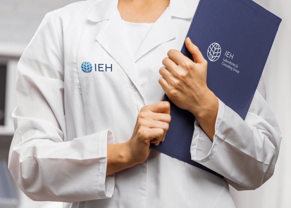 IEH promotional photograph of a person in a laboratory coat holding a blue folder