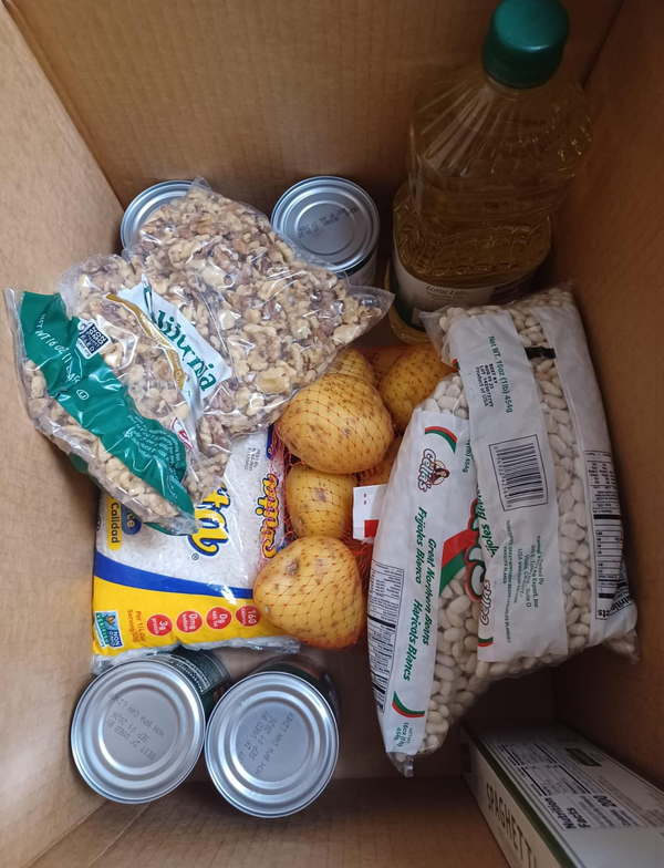 A food box containing beans, onions, cereal, canned goods and cooking oil