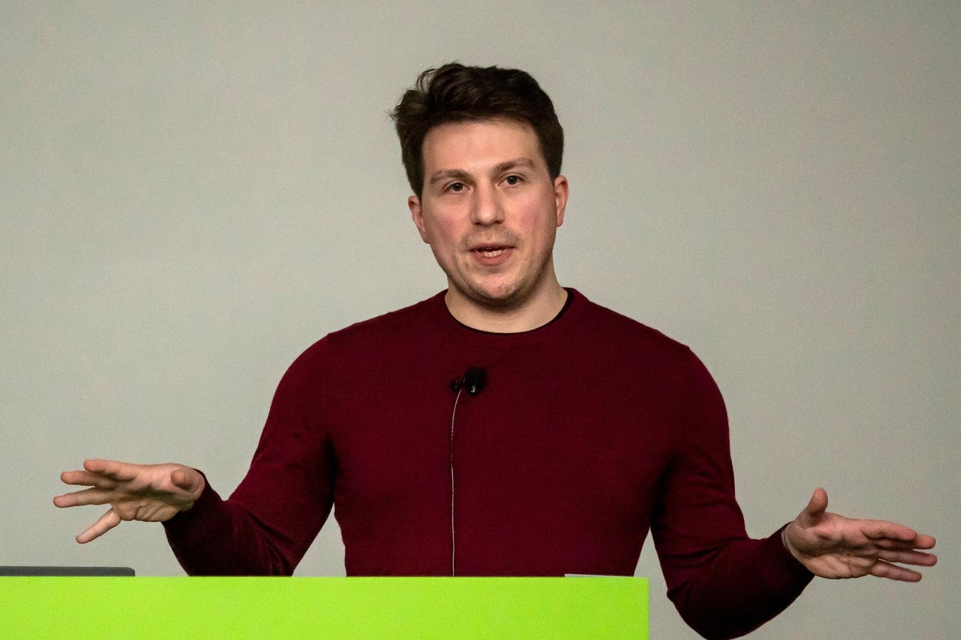 Igor Babuschkin speaking at a presentation, wearing a maroon sweater