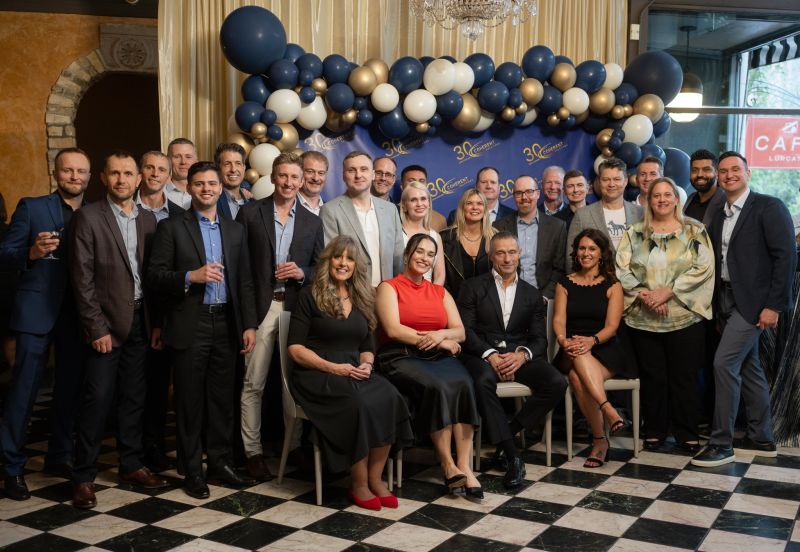 Colleagues and guests gathered beneath balloons at Coherent Solutions’ thirtieth-anniversary celebration