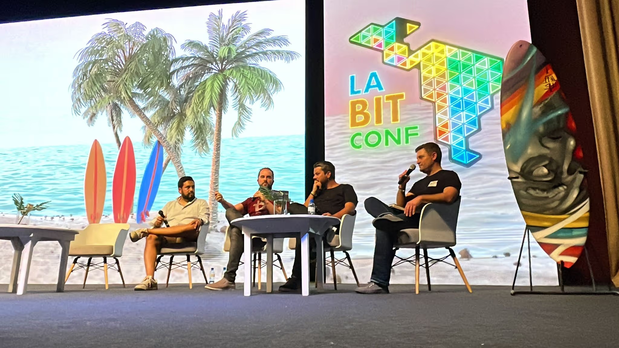 Four participants seated onstage during a LABITCONF panel in San Salvador in 2021