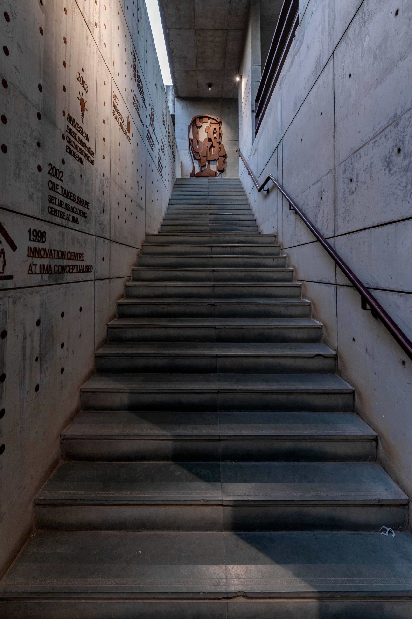 Concrete staircase at IIMA Ventures with milestones from its institutional history on the wall