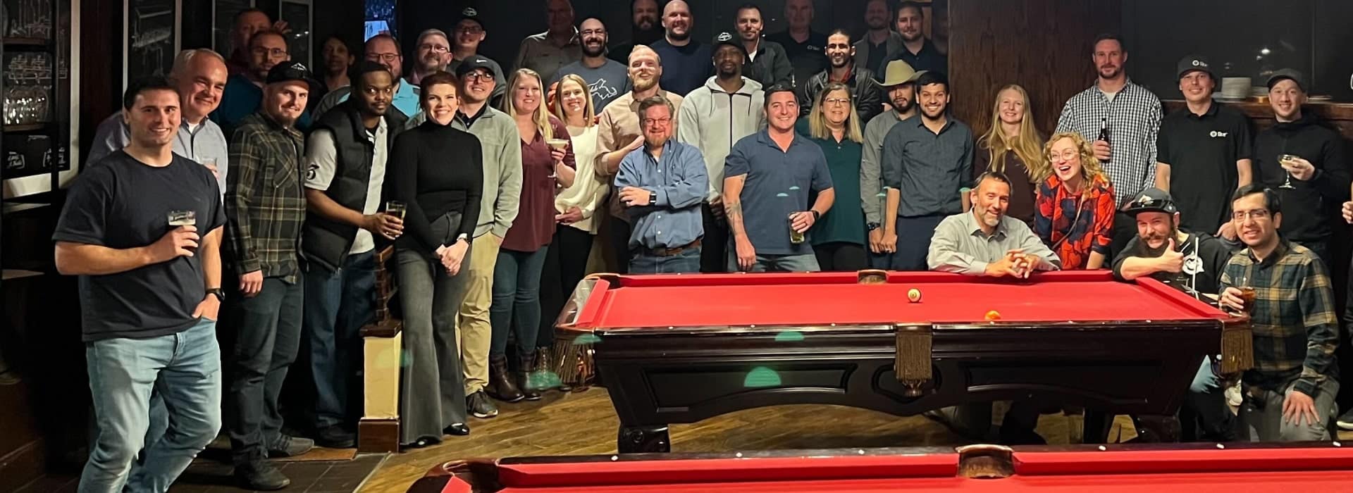 Members of the ikeGPS team gathered around pool tables