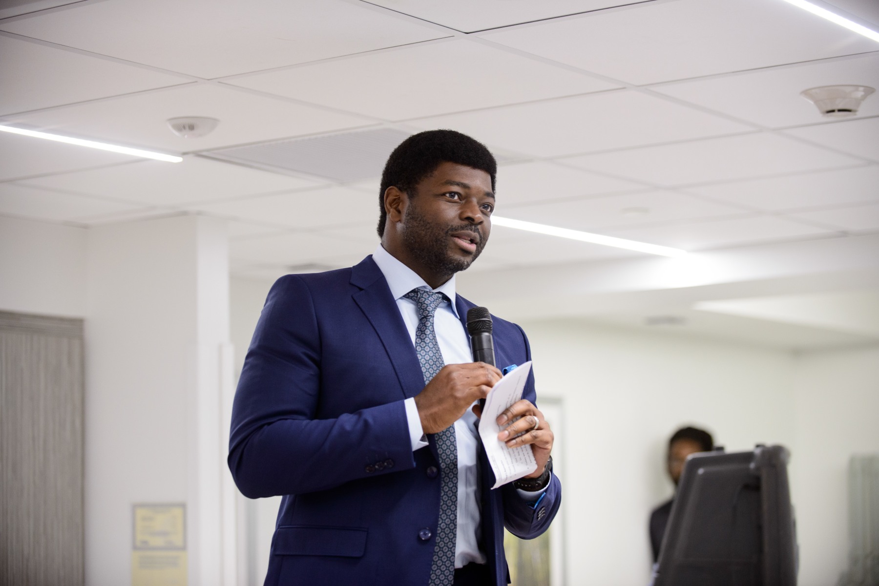 Ikenna Okezie speaking into a microphone at a Somatus event