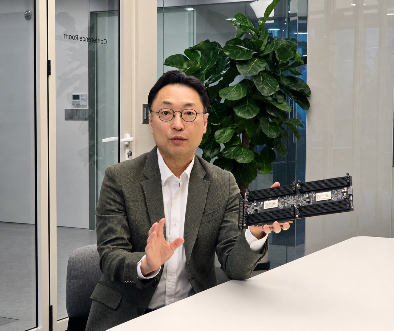 Il Park holds a memory expansion card while speaking at a table in Primemas’s Seongnam R&D center.