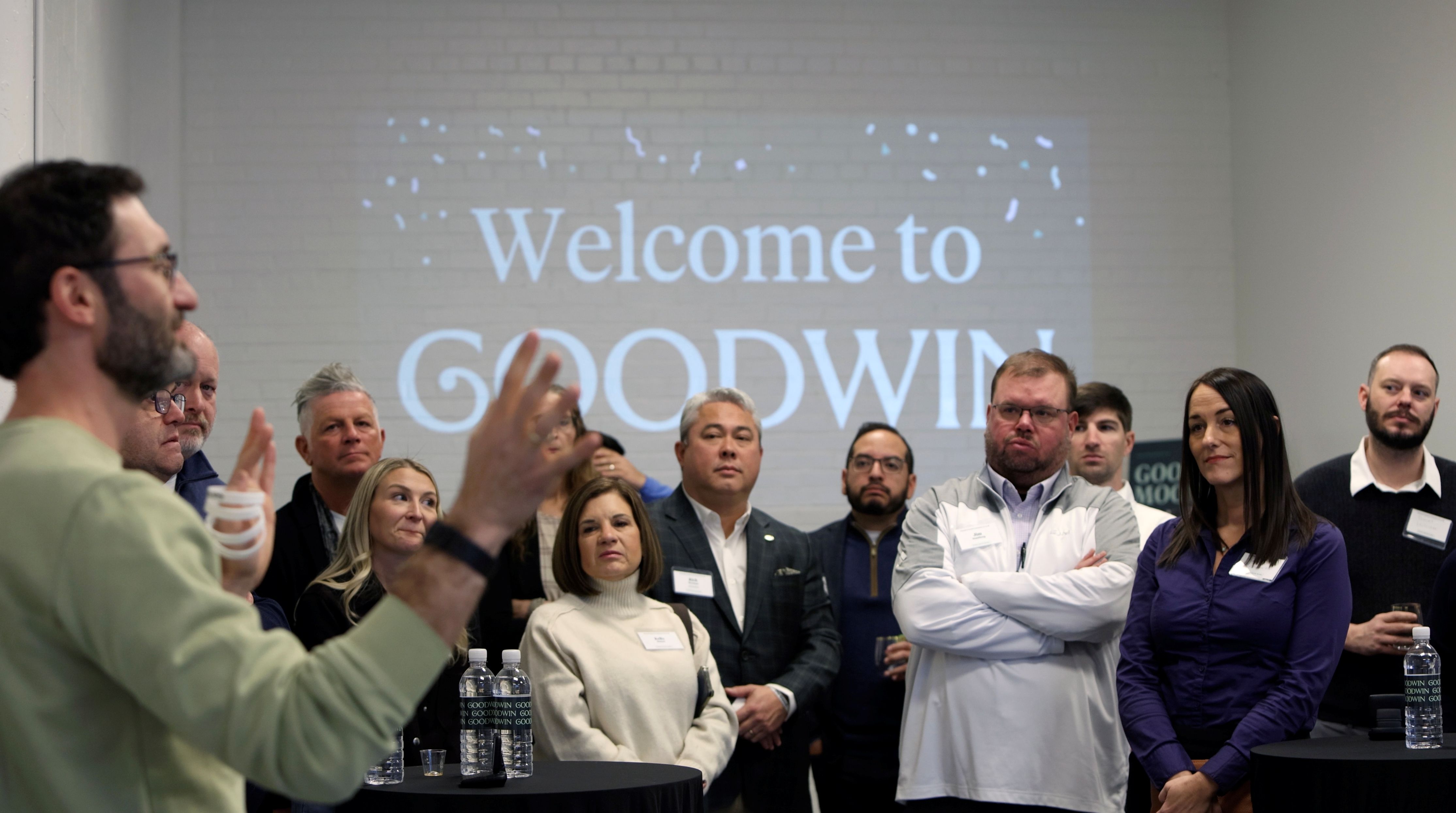 A Goodwin representative speaks to a group of attendees at a company gathering
