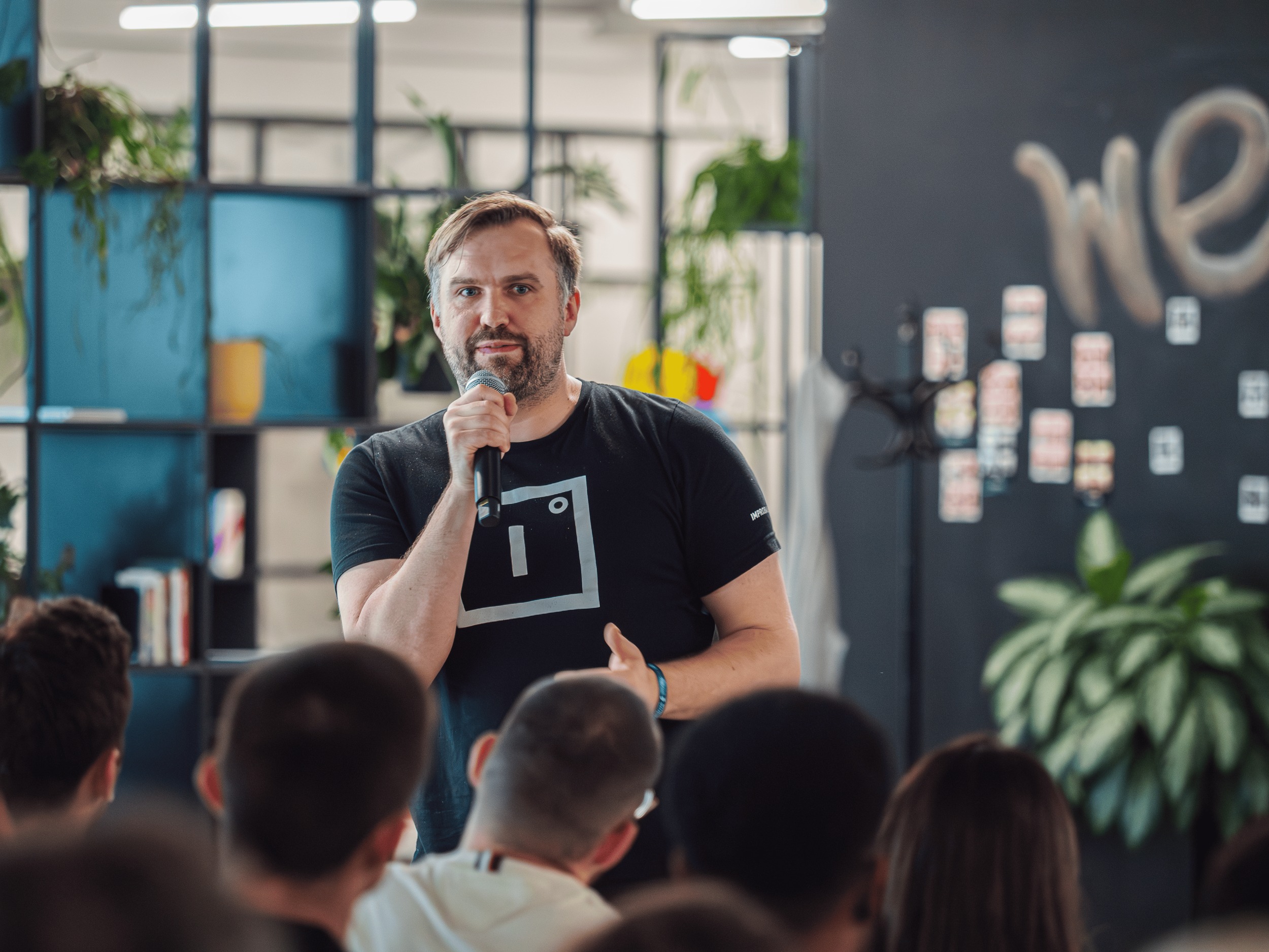 A speaker addressing a group at an Improbable office gathering