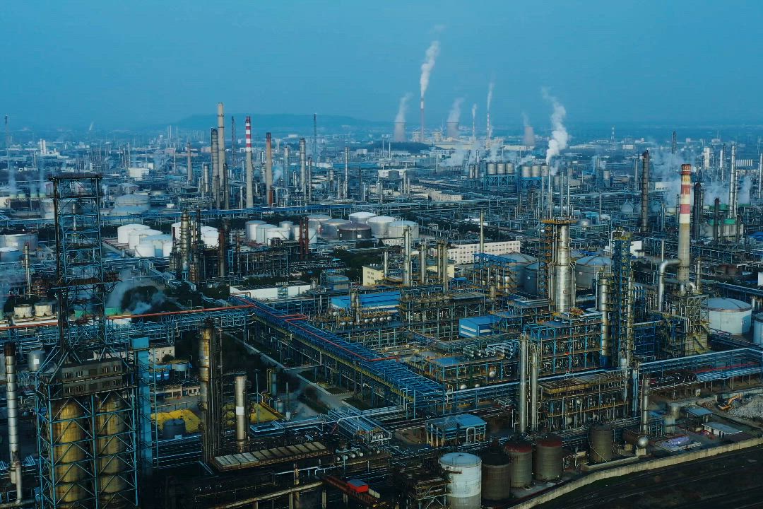 A wide view across a large refinery with towers, tanks and pipe racks