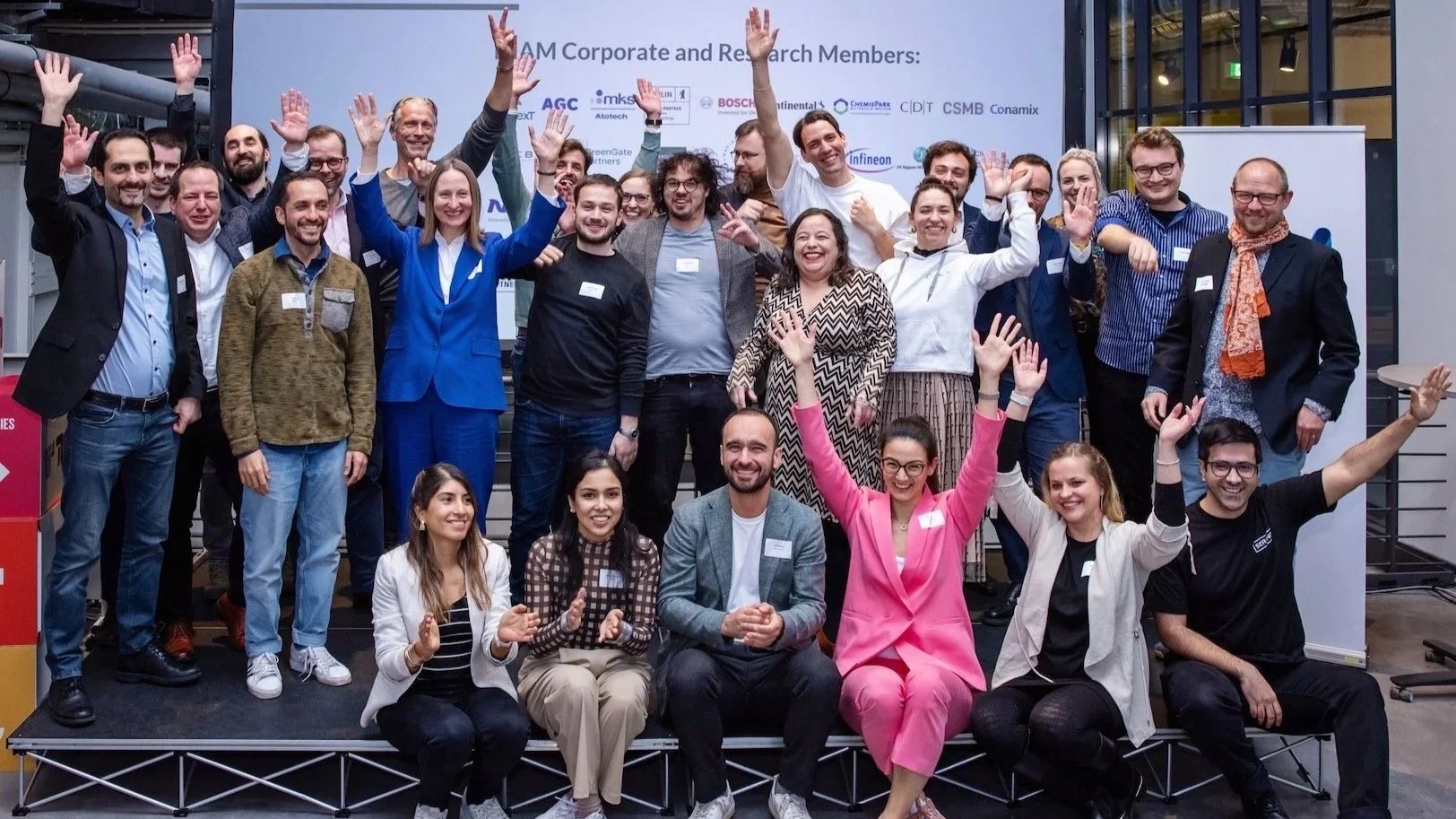AdMaCom 2024 participants and network members waving in a group photograph