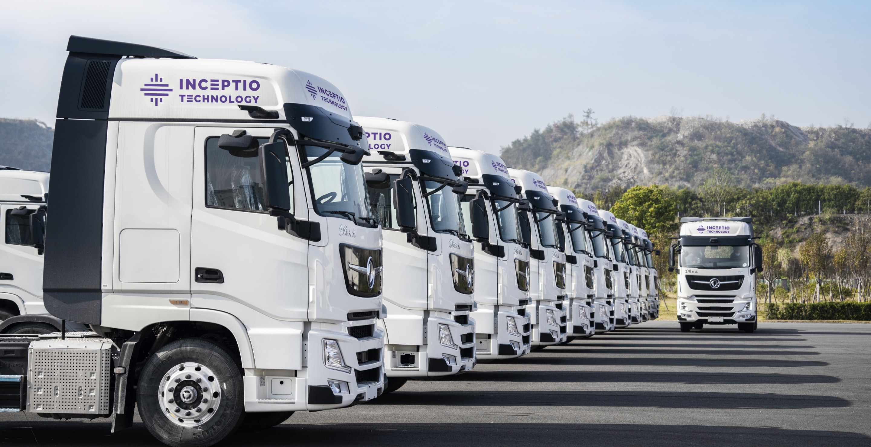 A fleet of Inceptio Technology autonomous heavy-duty trucks lined up, brand name visible on the cabs