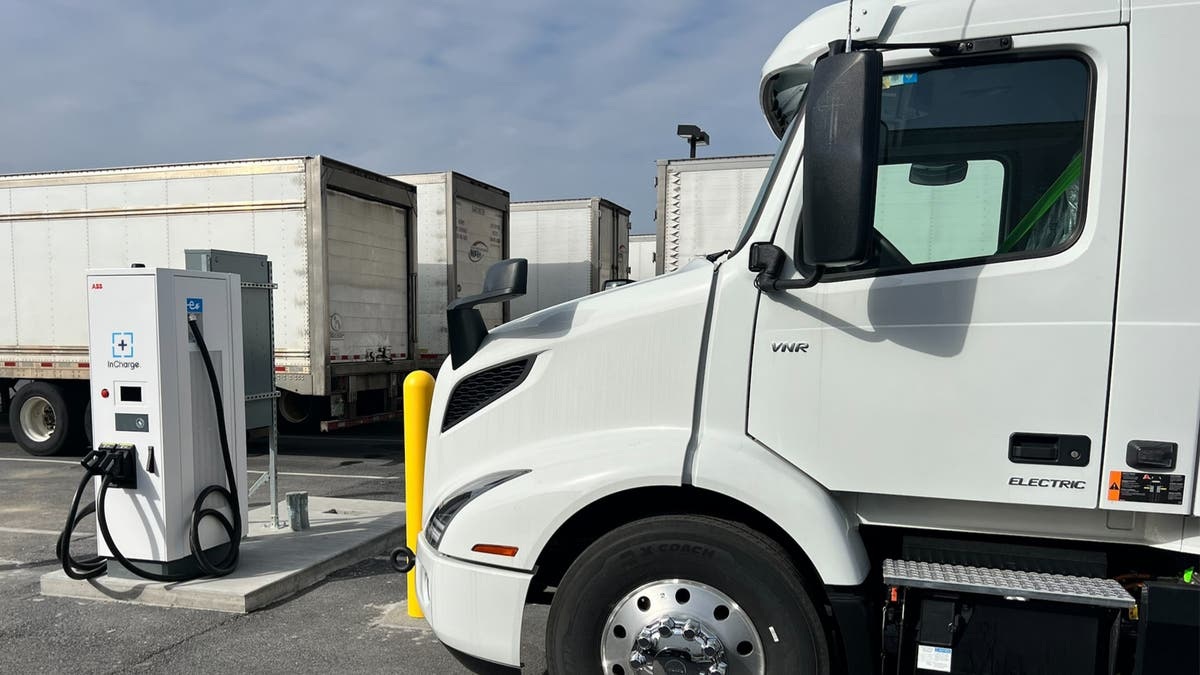 A Volvo VNR Electric truck beside InCharge charging equipment in a freight yard