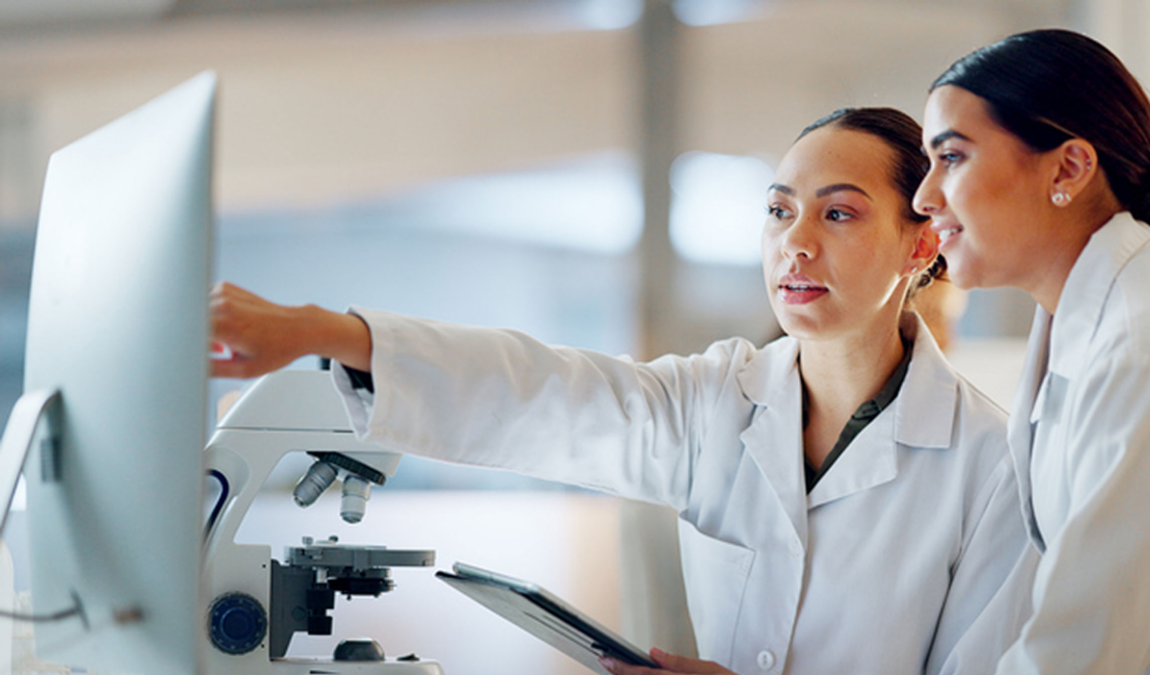 Two laboratory scientists studying results on a monitor