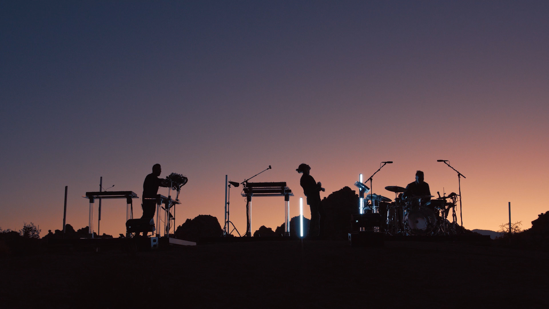 RÜFÜS DU SOL performing live under concert lighting