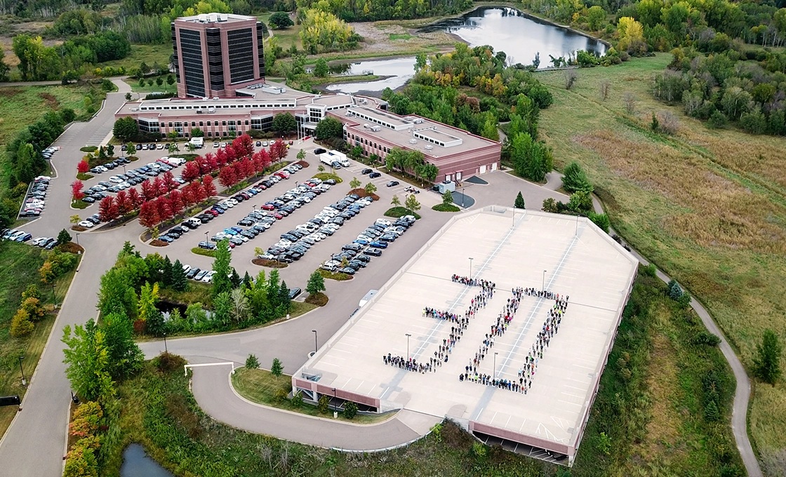 Infinite Campus employees form the number 30 on a parking structure for an aerial anniversary photograph