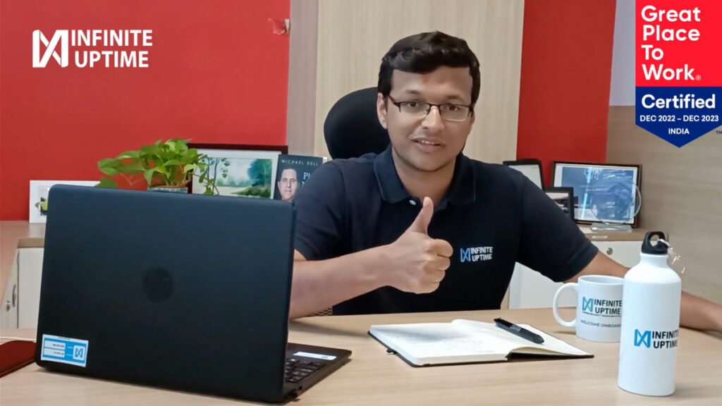 An office photograph from the Infinite Uptime portfolio gallery, with an employee giving a thumbs-up at a desk
