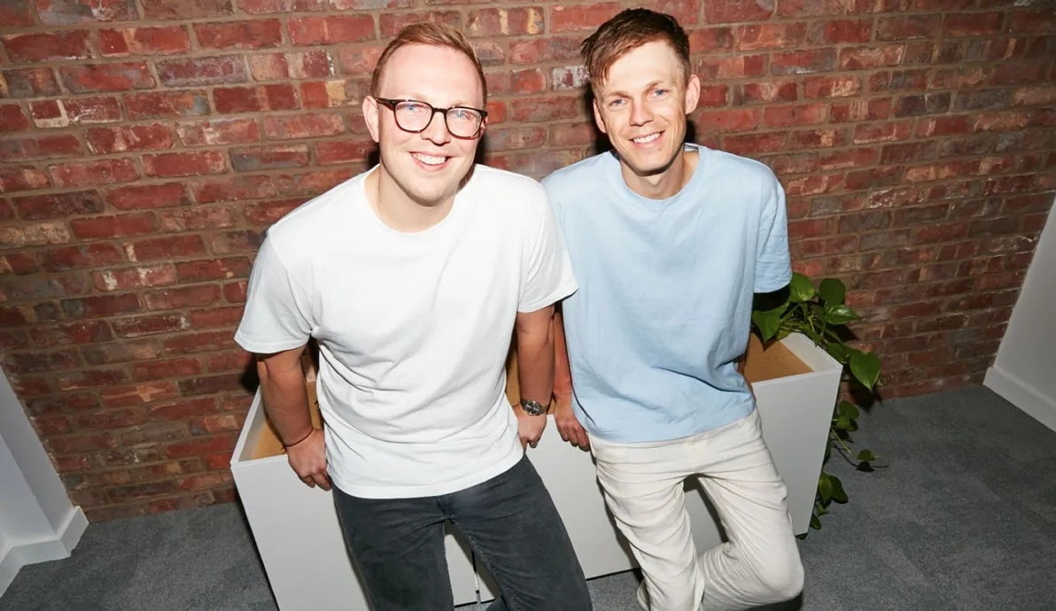 Influencer co-founders pictured together against an exposed brick wall
