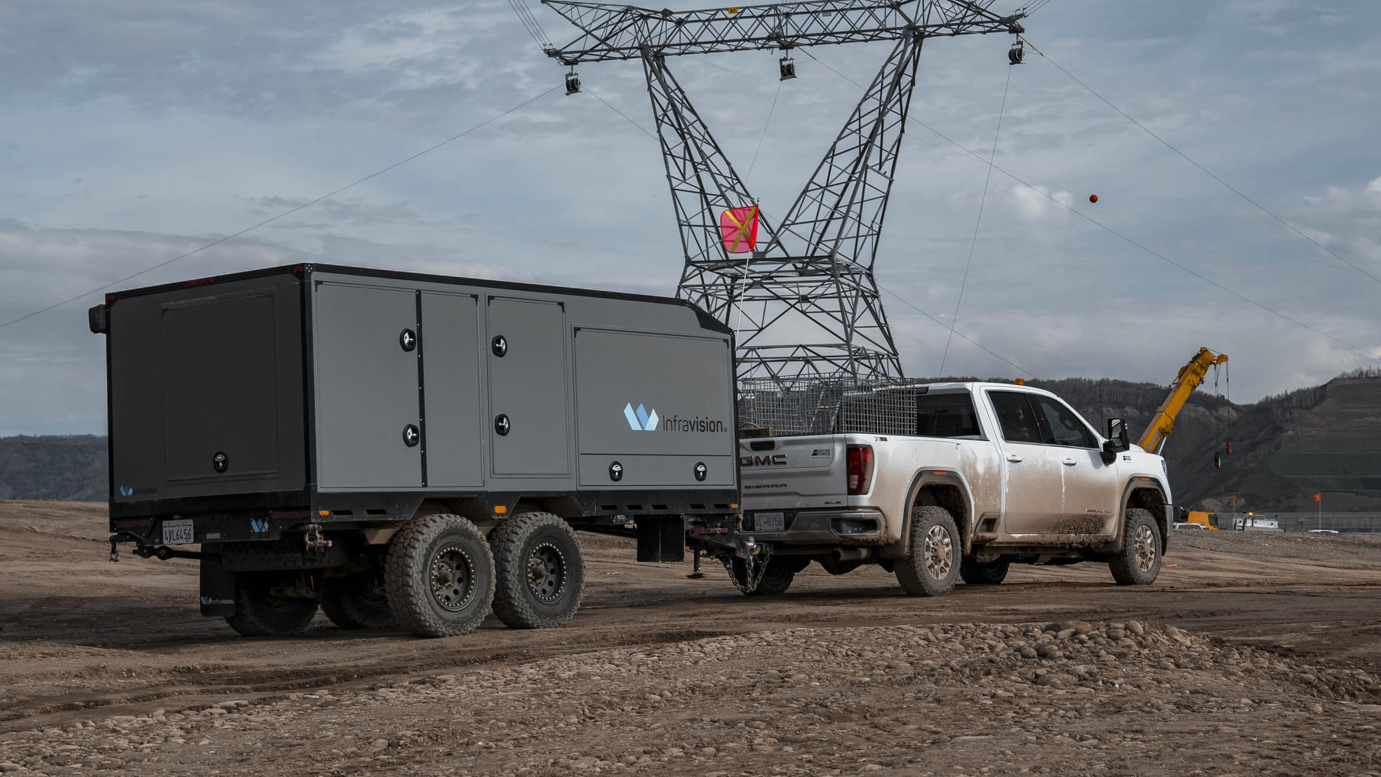 An Infravision equipment trailer attached to a pickup truck at a transmission construction site