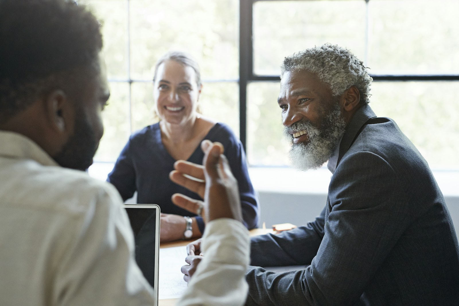 Three colleagues in conversation around a table