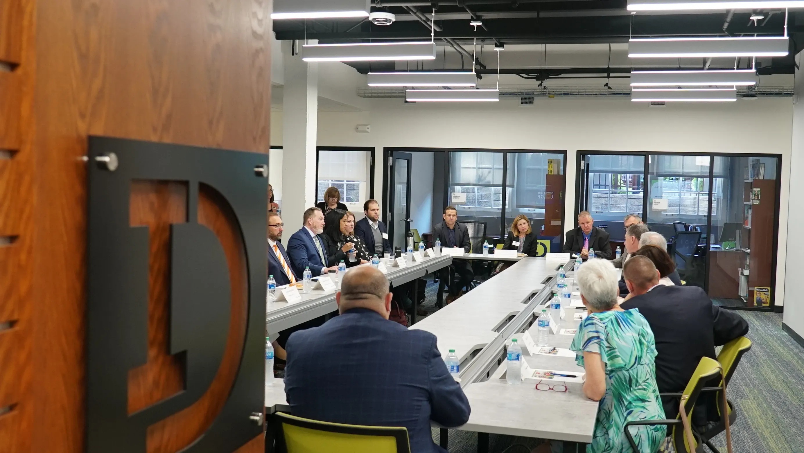 People gathered around tables inside Innovation DuPage’s meeting space