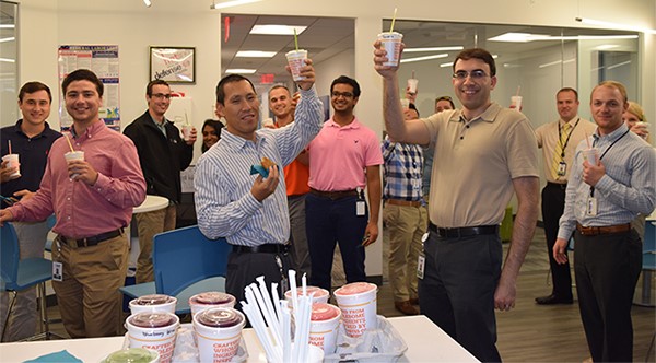 IDT employees raising smoothie cups during an office gathering