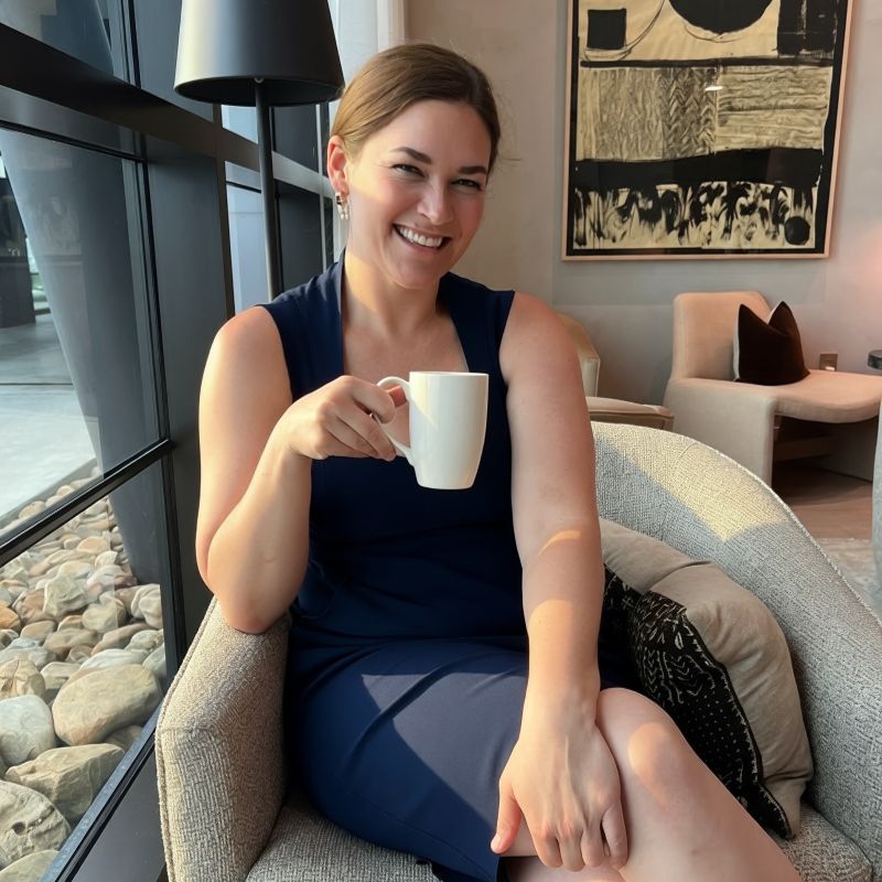 Kat Kovalchik McDavitt seated with a coffee cup