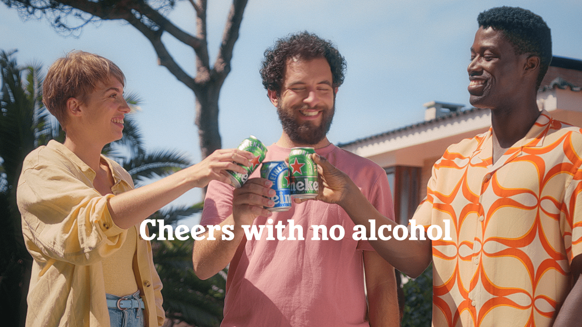 Heineken campaign still showing three people raising cans, with the line Cheers with no alcohol