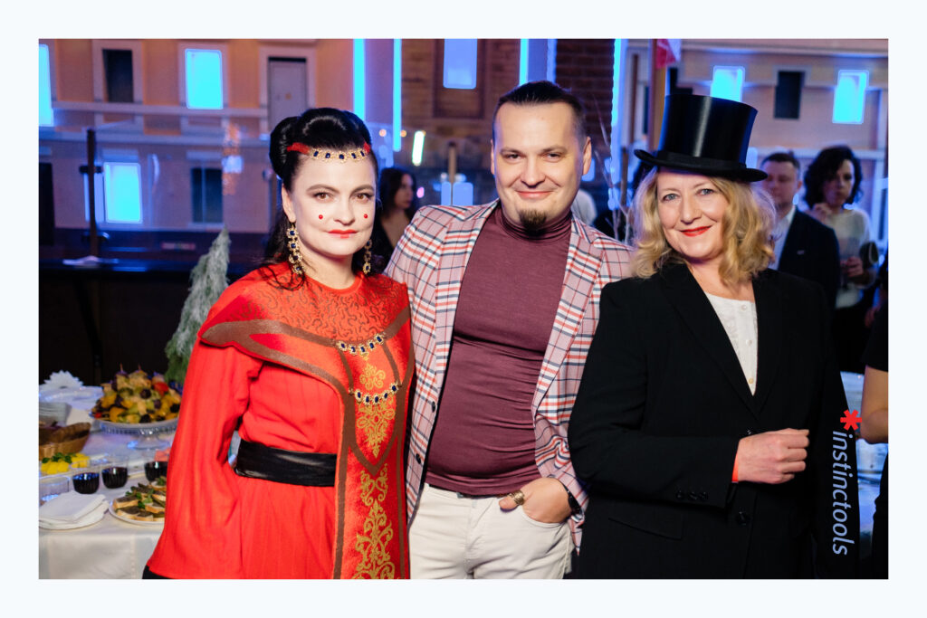 Three attendees in colorful outfits at an Instinctools company event, in an archival photograph published in 2021