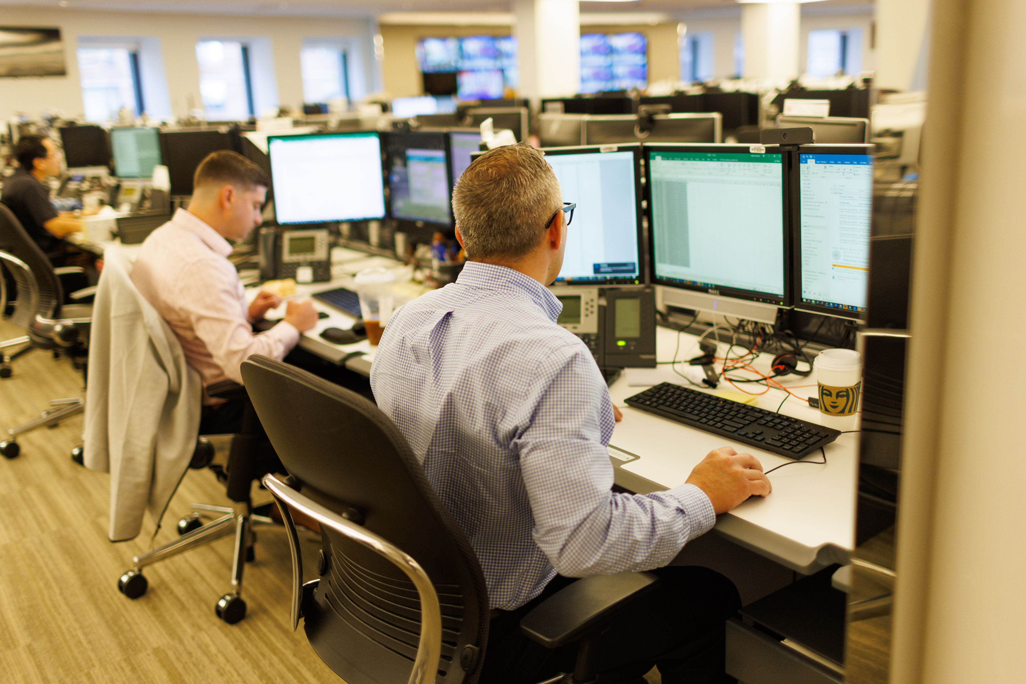 Two colleagues at Instinet reviewing trading screens