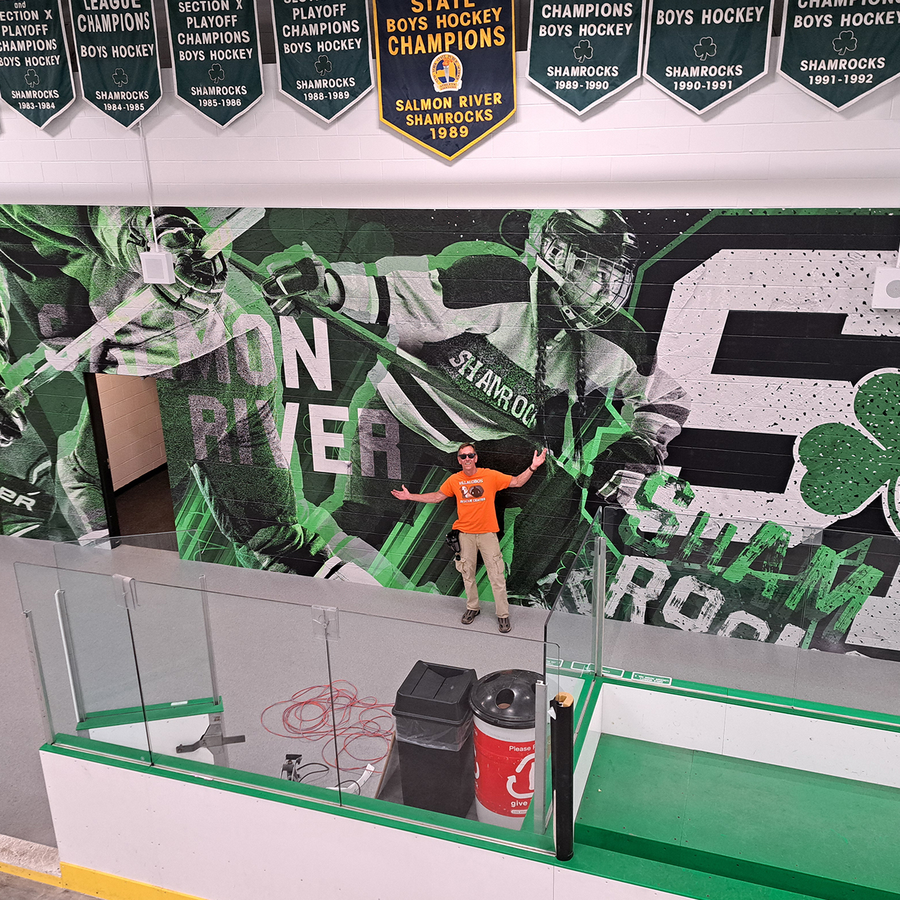 A large green and black hockey mural installed across an indoor arena wall