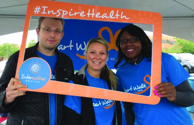 Three people pictured holding an orange InspireHealth frame in the 2017 HERO case study