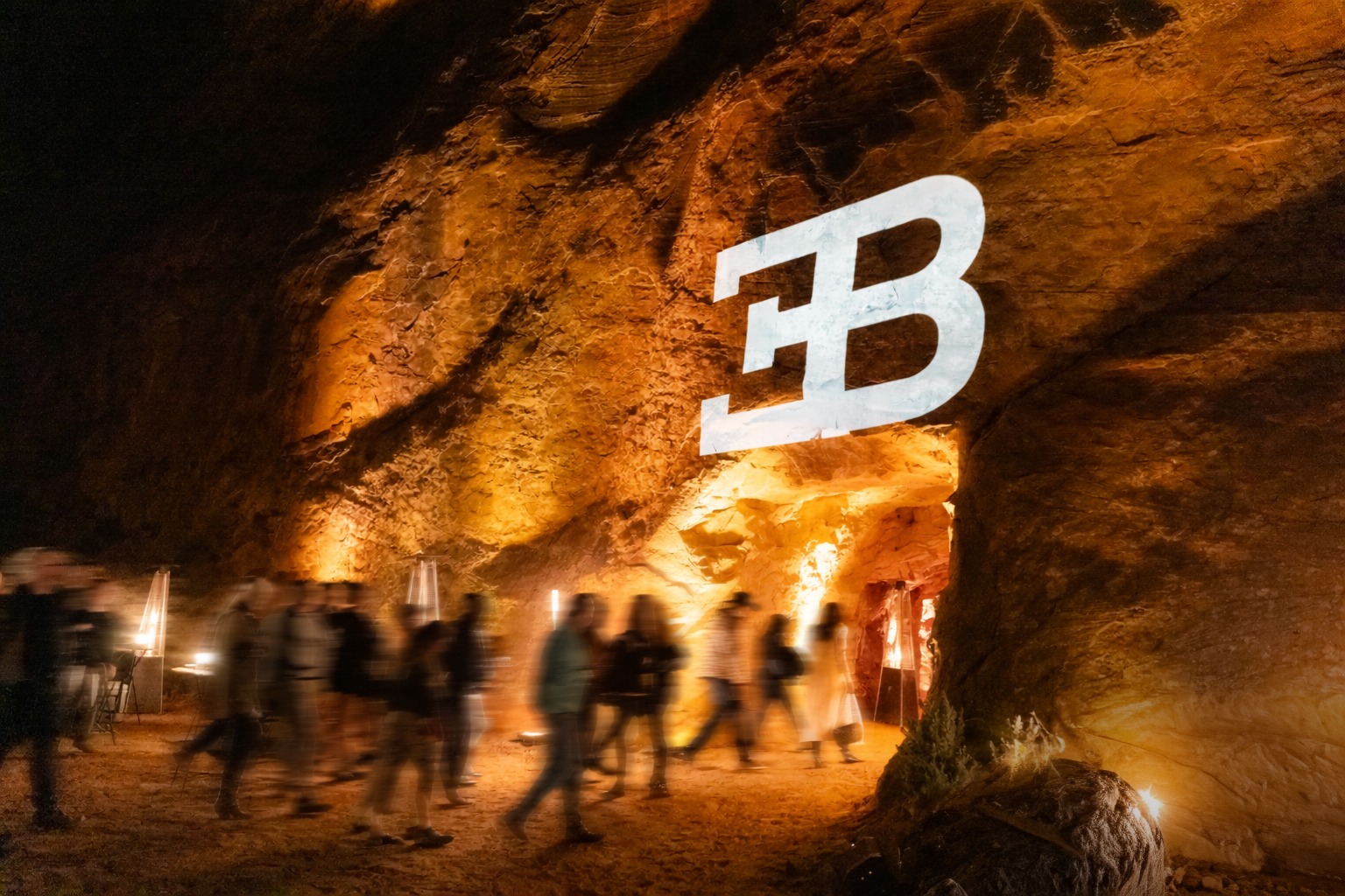 Guests walk through an illuminated canyon during a Bugatti Grand Tour experience