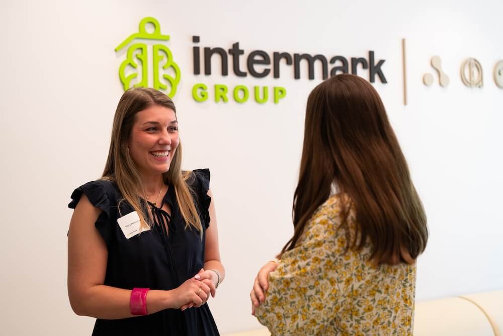 Two people speaking in the lobby of Intermark Group's Highland Avenue office