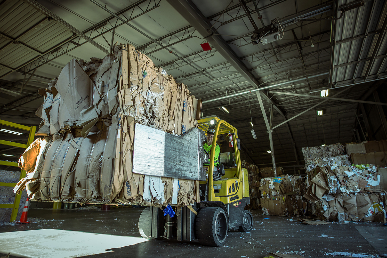 Forklift handling compressed bales of recovered material at a recycling facility