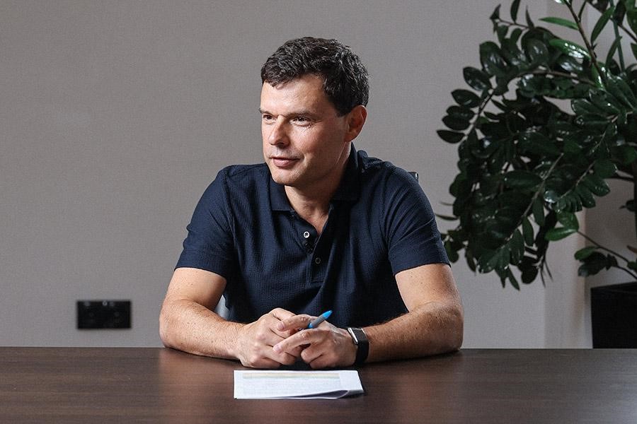 IIDF director Kirill Varlamov seated at a table with a pen and notebook
