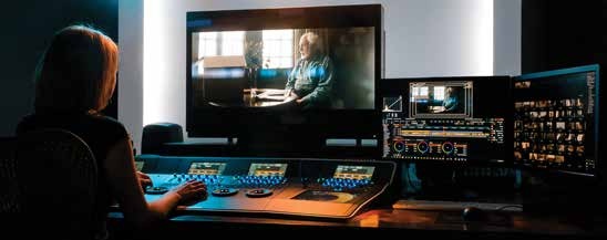 An operator at a color-grading console in Roundtable Films’ suite, with a large picture monitor and two workstation displays