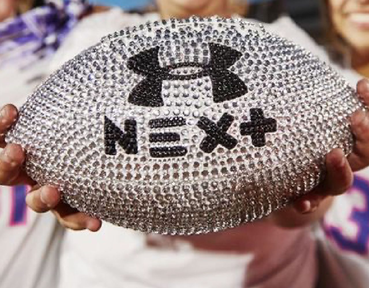 A sparkling UA Next football held toward the camera