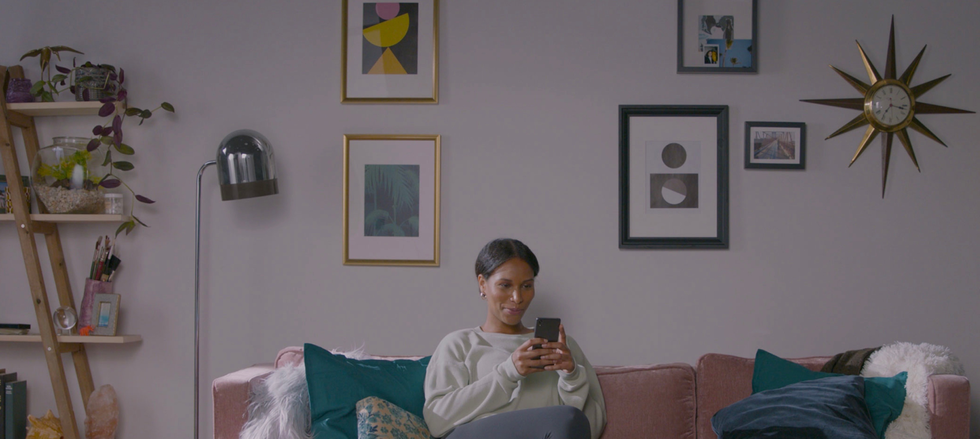 Intro brand photograph of a woman using her phone on a sofa