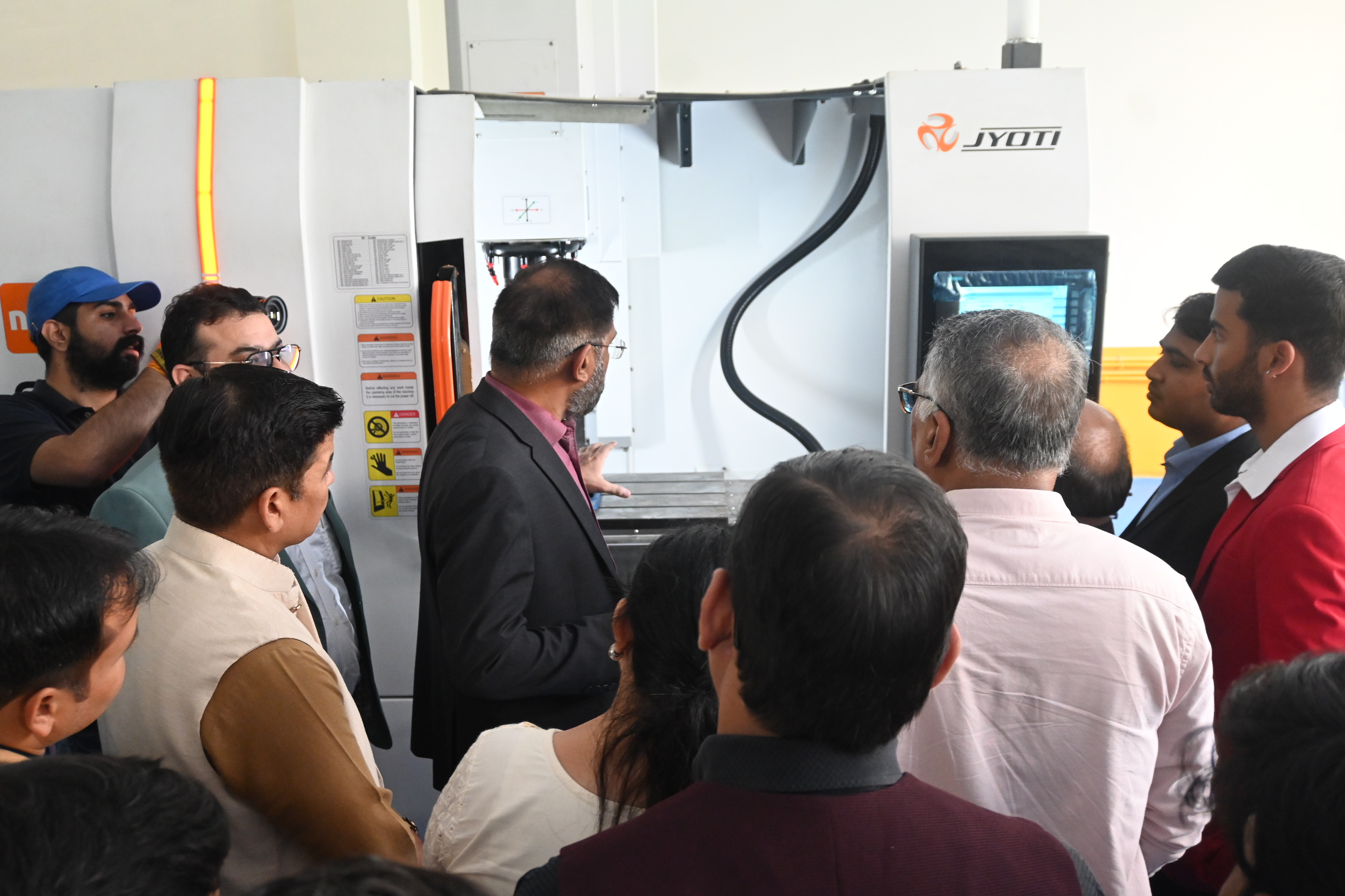 Visitors examining industrial machinery during an Invertis campus lab visit
