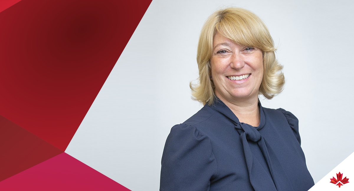 Invest in Canada CEO Laurel Broten standing before the agency's geometric red branding