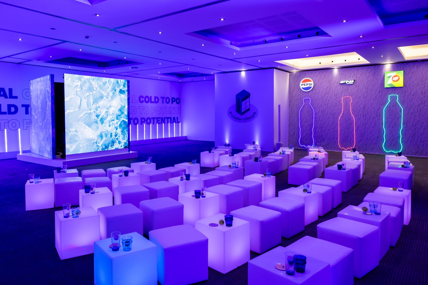 PepsiCo conference room with illuminated bottle outlines and rows of white seats
