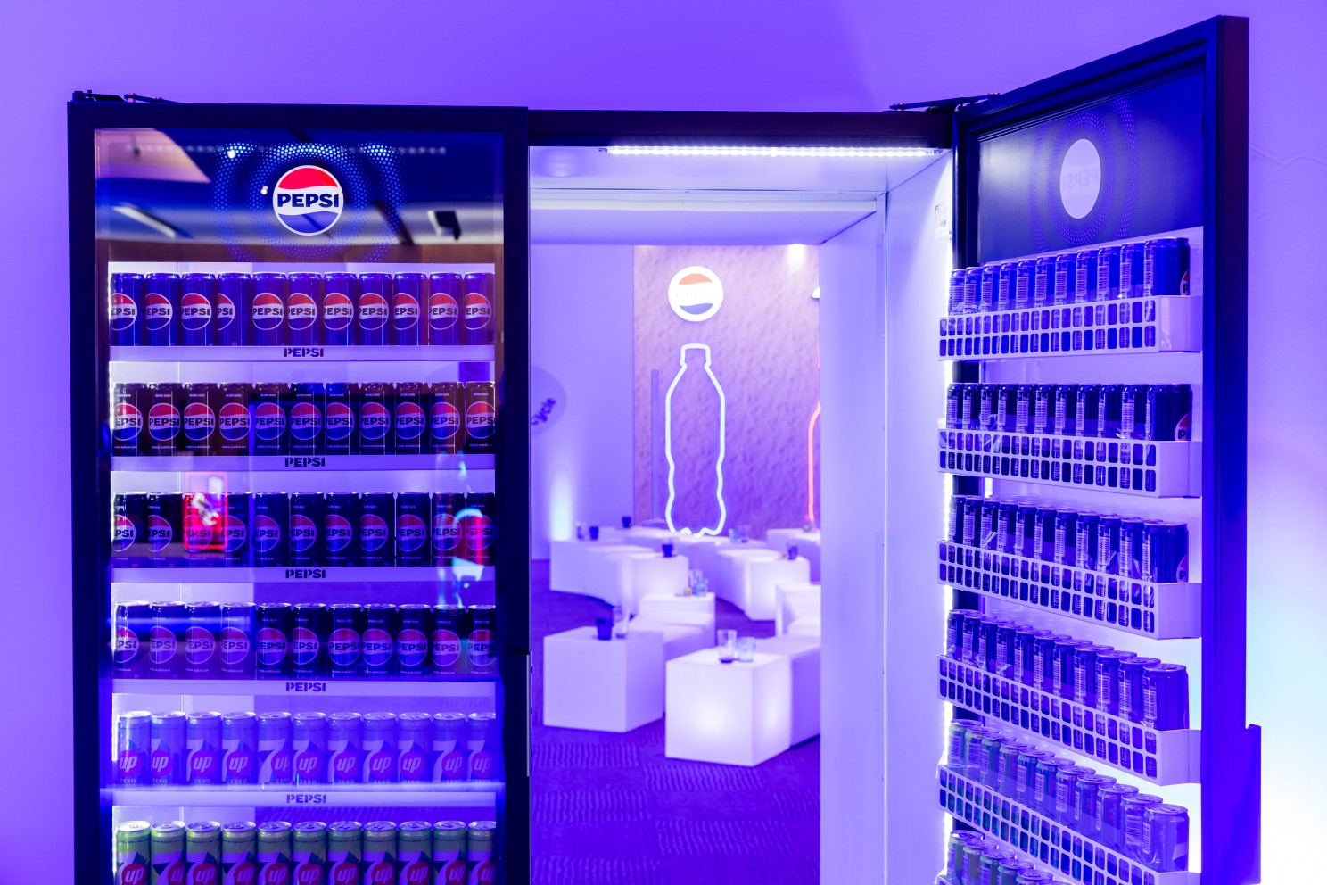 Pepsi-branded cooler doors open into a purple-lit conference breakout room