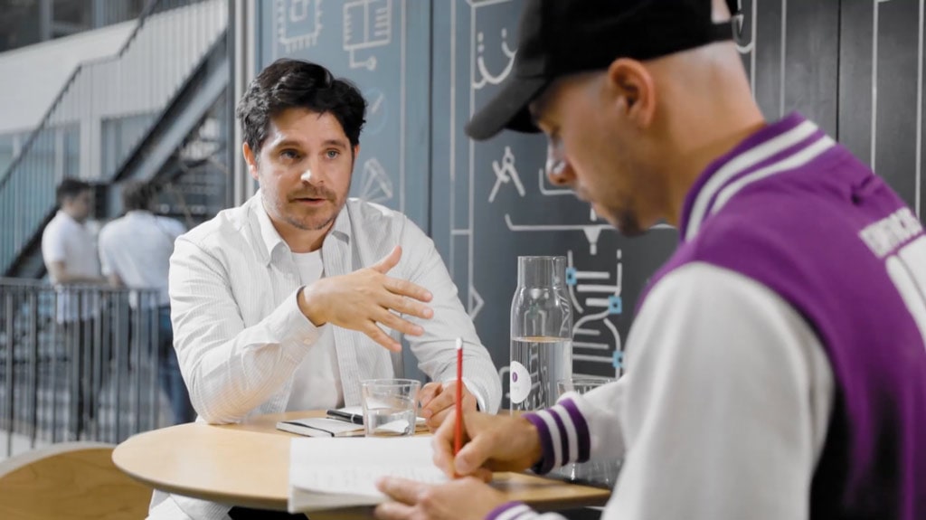 Two people talking and taking notes at a shared table in IoT Valley