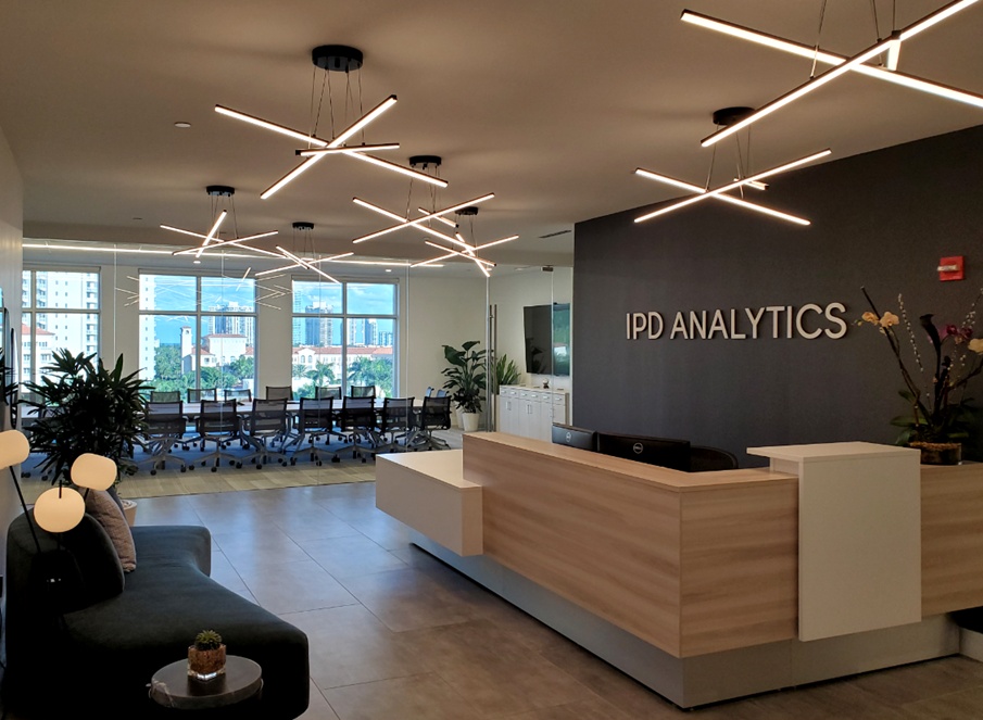 IPD Analytics reception area with a glass meeting room and angular pendant lights