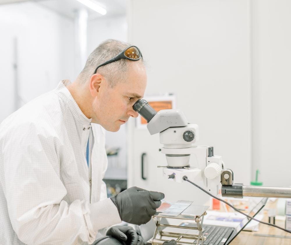 An IPG application development specialist examines a sample through a microscope