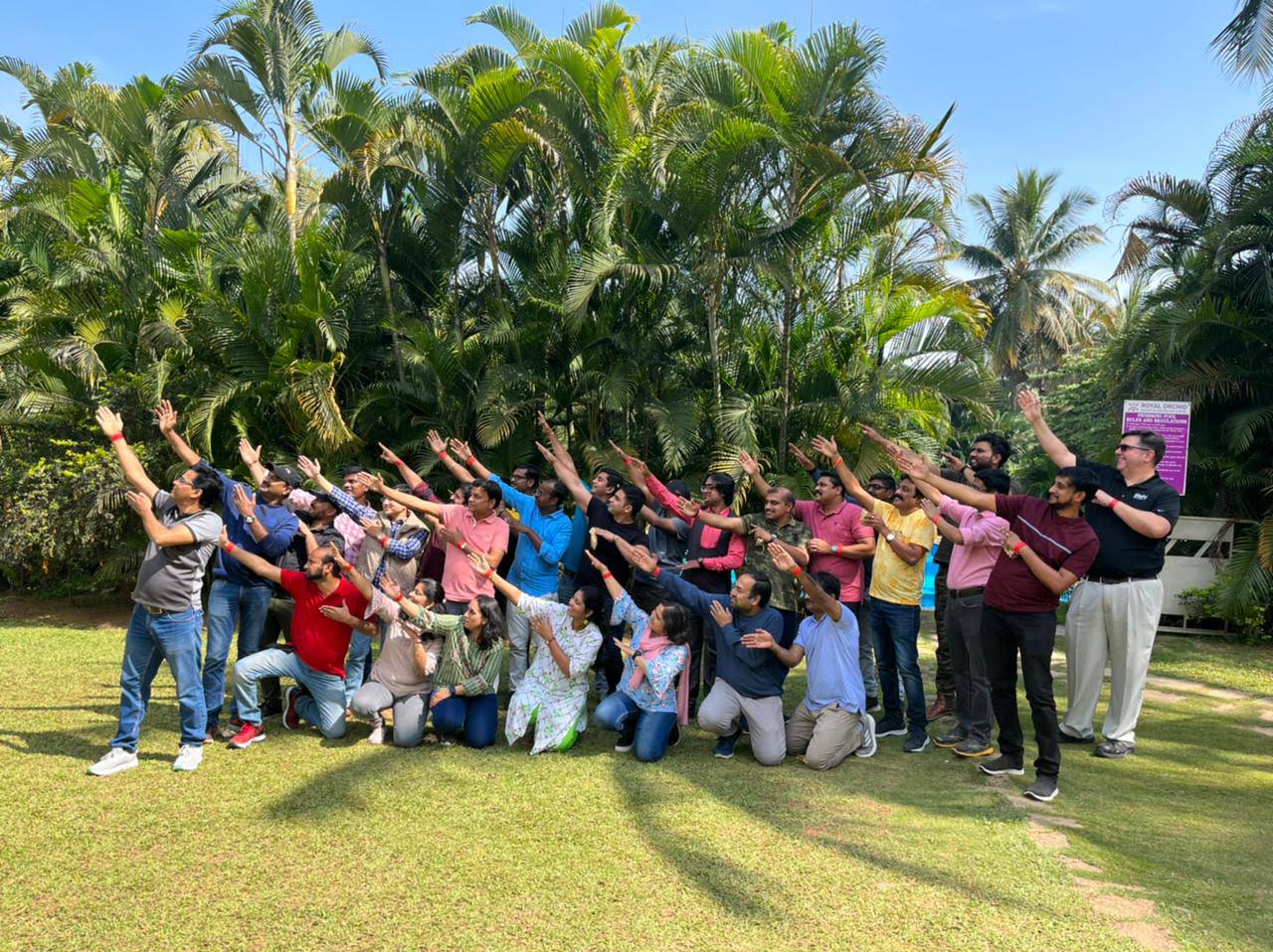 iRely colleagues posing together outdoors beneath palm trees