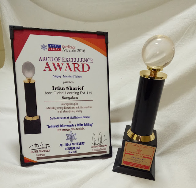 Framed Arch of Excellence Award naming Irfan Sharief beside a globe-topped trophy